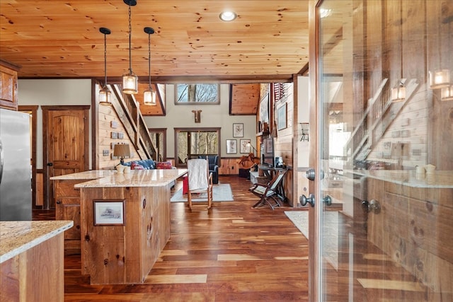 kitchen featuring wood finished floors, a center island, stainless steel fridge, wood ceiling, and hanging light fixtures