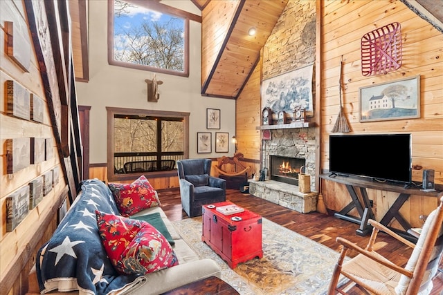 living room with a stone fireplace, wood finished floors, wood ceiling, and wood walls