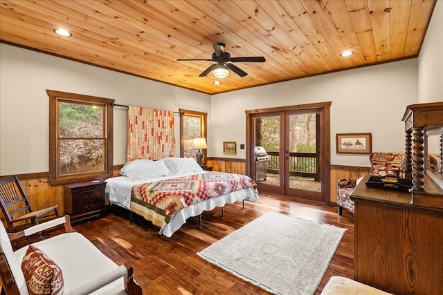 bedroom with access to outside, multiple windows, wood ceiling, and a wainscoted wall