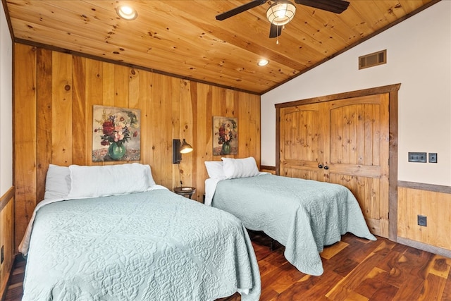 bedroom with wooden walls, dark wood-style floors, visible vents, lofted ceiling, and wooden ceiling