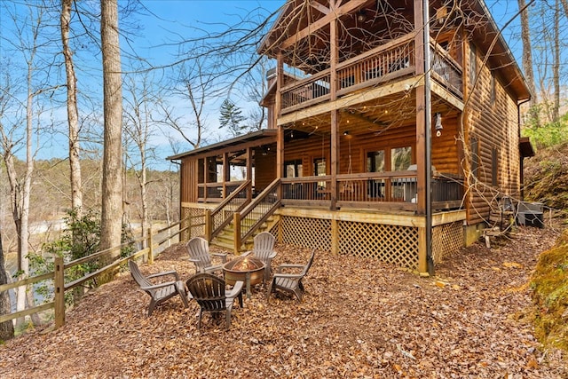 rear view of house with a fire pit, a deck, and stairs