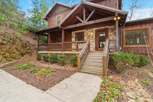 view of front of property with a porch, stone siding, and board and batten siding