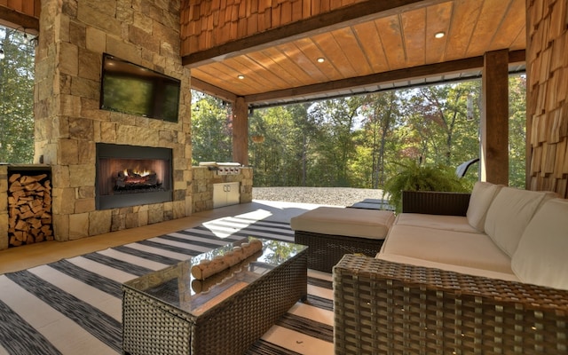 exterior space with an outdoor living space with a fireplace and a patio