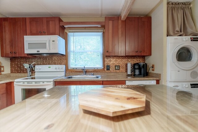 kitchen with decorative backsplash, stacked washer and clothes dryer, white appliances, and sink