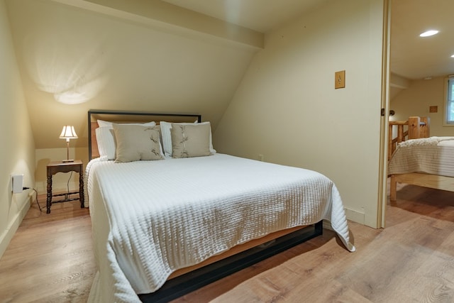 bedroom featuring lofted ceiling and light hardwood / wood-style floors