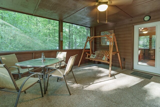 unfurnished sunroom with wood ceiling and ceiling fan