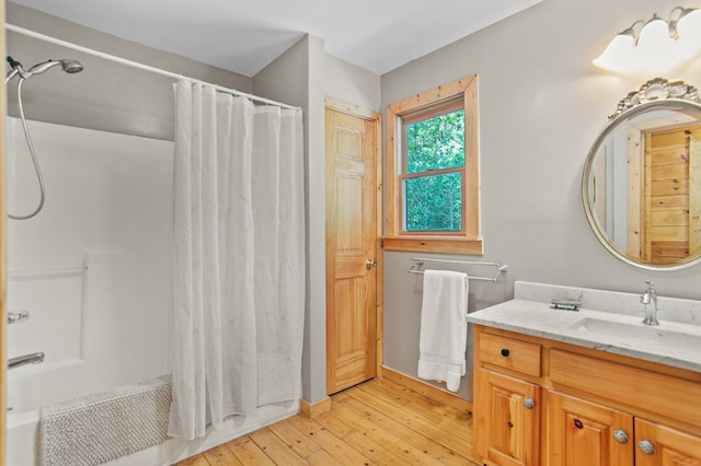 bathroom featuring wood-type flooring, shower / tub combo with curtain, and vanity