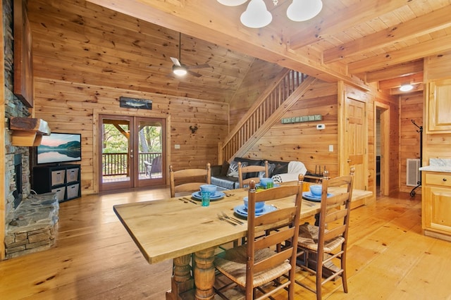 dining area with wood walls, ceiling fan, and light hardwood / wood-style flooring