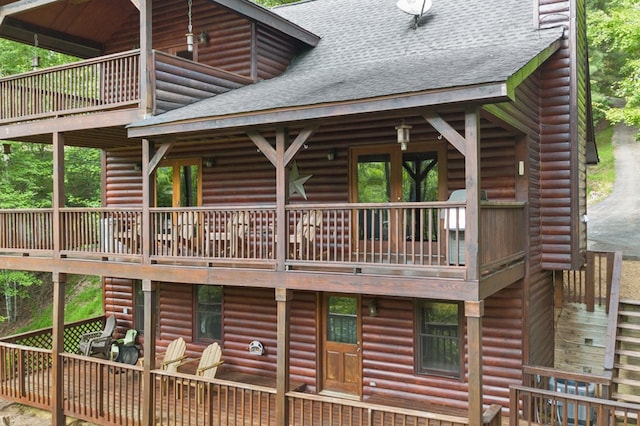 rear view of property featuring a balcony and a deck