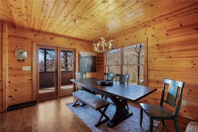 dining area with wood ceiling, wooden walls, french doors, and hardwood / wood-style flooring