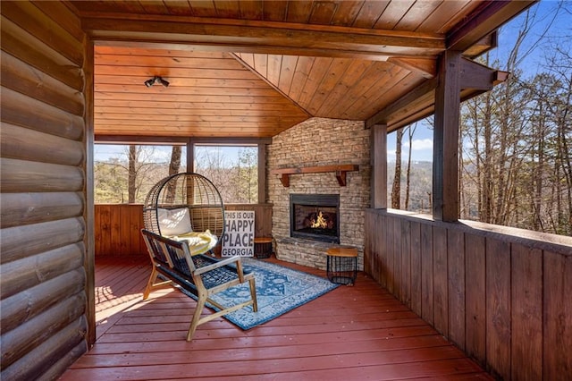 unfurnished sunroom featuring wood ceiling, an outdoor stone fireplace, vaulted ceiling, and a wealth of natural light