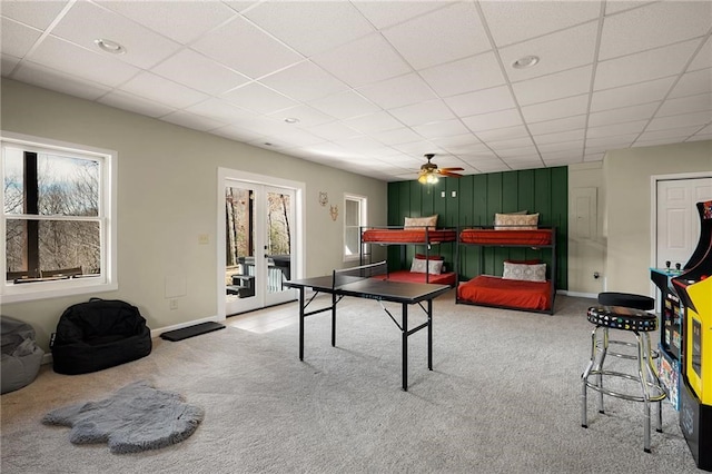 recreation room with carpet flooring, a drop ceiling, and french doors