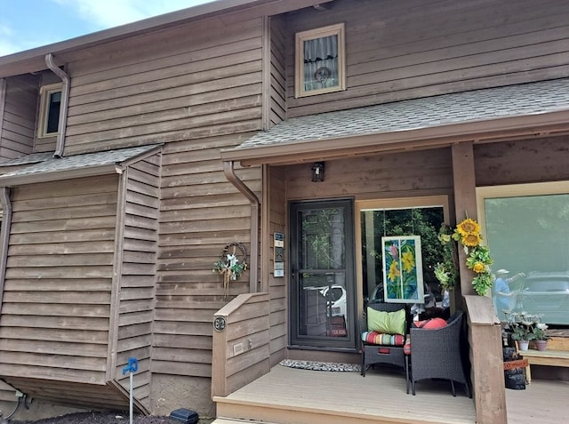 doorway to property with a shingled roof