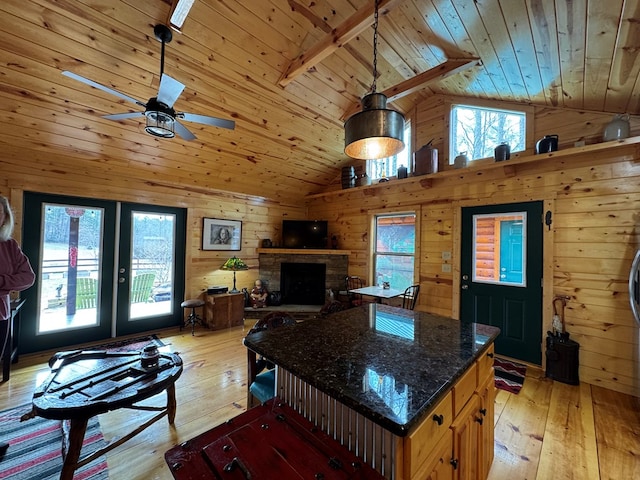 kitchen featuring a healthy amount of sunlight, wood ceiling, and wooden walls