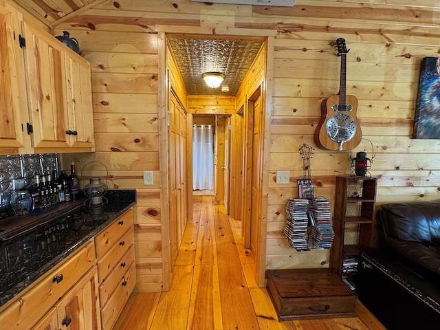 kitchen featuring light hardwood / wood-style flooring, light brown cabinetry, and wood walls