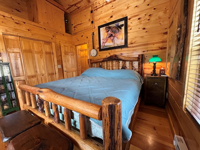 bedroom with wooden walls and baseboard heating