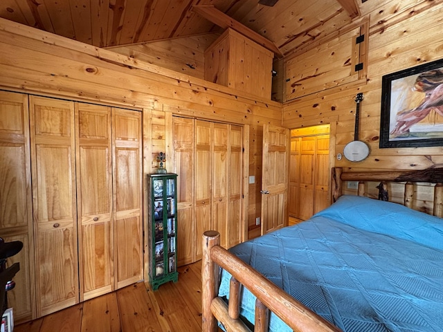 bedroom with wood walls, lofted ceiling, light wood-type flooring, and wooden ceiling