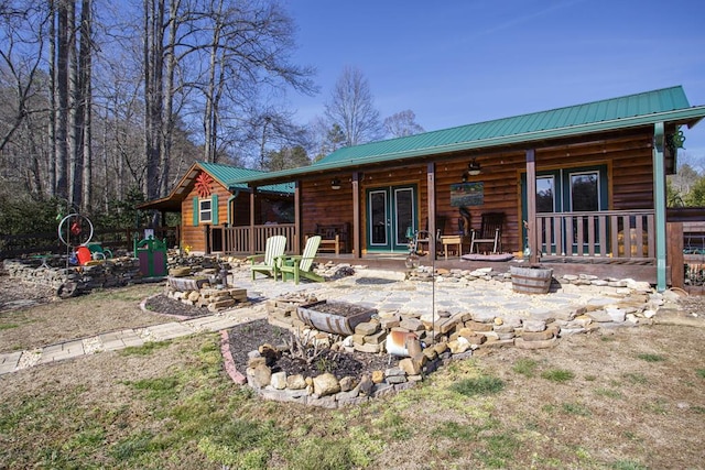 rear view of house featuring french doors, a patio area, and a fire pit