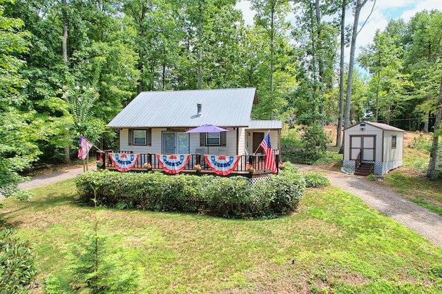 view of front facade with a storage unit, a front yard, and a wooden deck