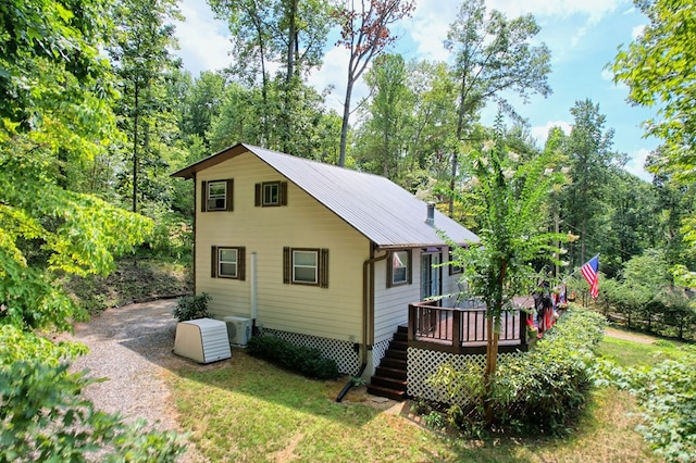 view of side of home featuring a yard and a deck