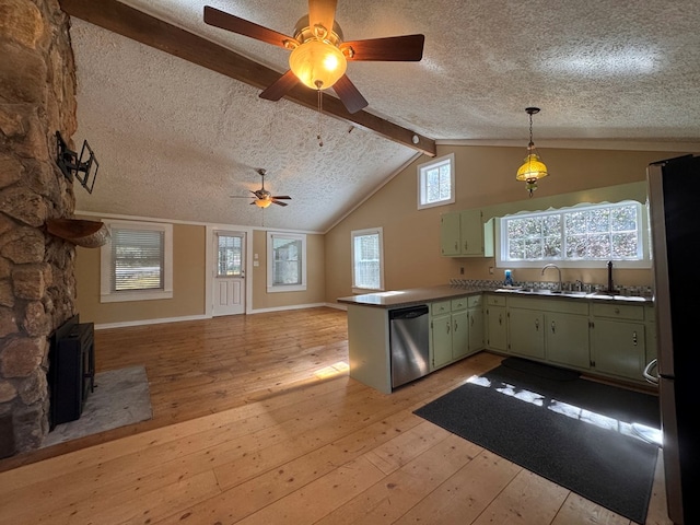 kitchen featuring appliances with stainless steel finishes, vaulted ceiling with beams, a peninsula, light wood-type flooring, and green cabinetry