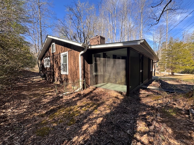 view of home's exterior with a chimney and a wall mounted air conditioner