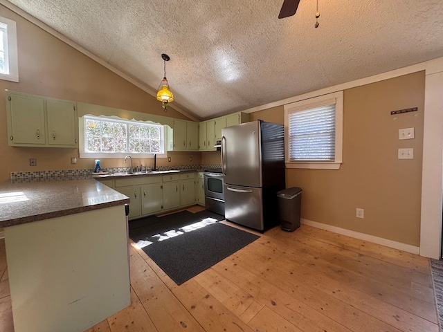 kitchen featuring appliances with stainless steel finishes, a sink, vaulted ceiling, light wood-type flooring, and green cabinetry