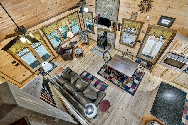 4527 Gates Chapel Rd, Ellijay, GA 30540 - living area featuring a ceiling fan, hardwood / wood-style floors, a wood stove, wood walls, and a high ceiling