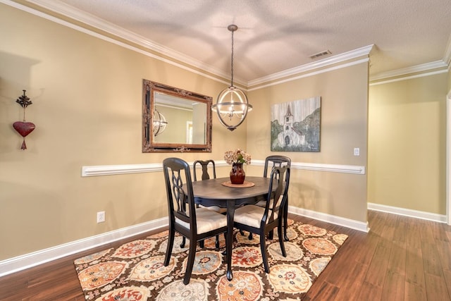 dining space featuring a textured ceiling, hardwood / wood-style flooring, an inviting chandelier, and crown molding