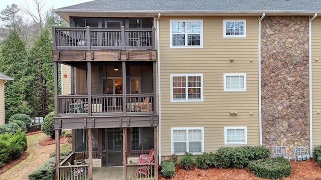 back of house featuring a sunroom, a balcony, and a patio