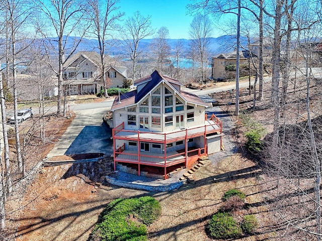 rear view of property with driveway and a wooden deck