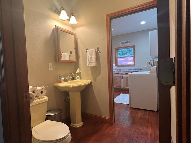 bathroom featuring hardwood / wood-style floors, toilet, sink, and washer / clothes dryer