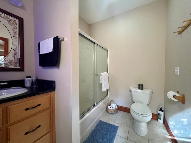 full bathroom featuring tile patterned flooring, vanity, toilet, and bath / shower combo with glass door