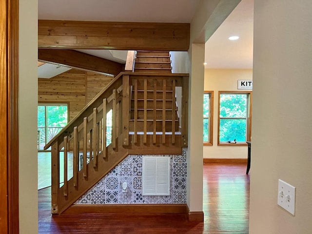 stairway with beam ceiling and hardwood / wood-style flooring