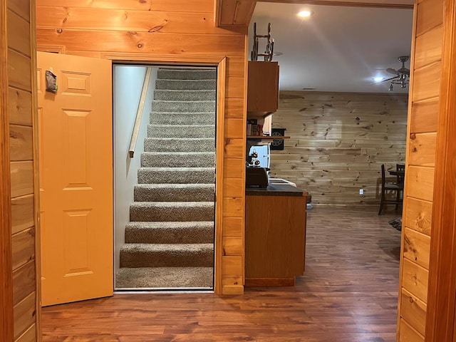 stairway featuring wood-type flooring and wooden walls