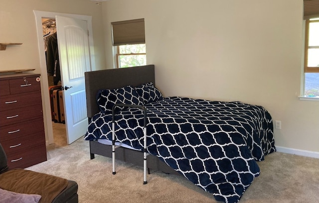 bedroom with light carpet, a walk in closet, and a closet