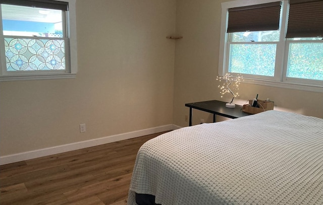 bedroom with dark hardwood / wood-style flooring