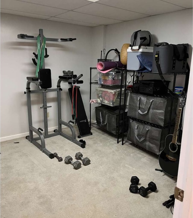 workout room with light colored carpet and a drop ceiling