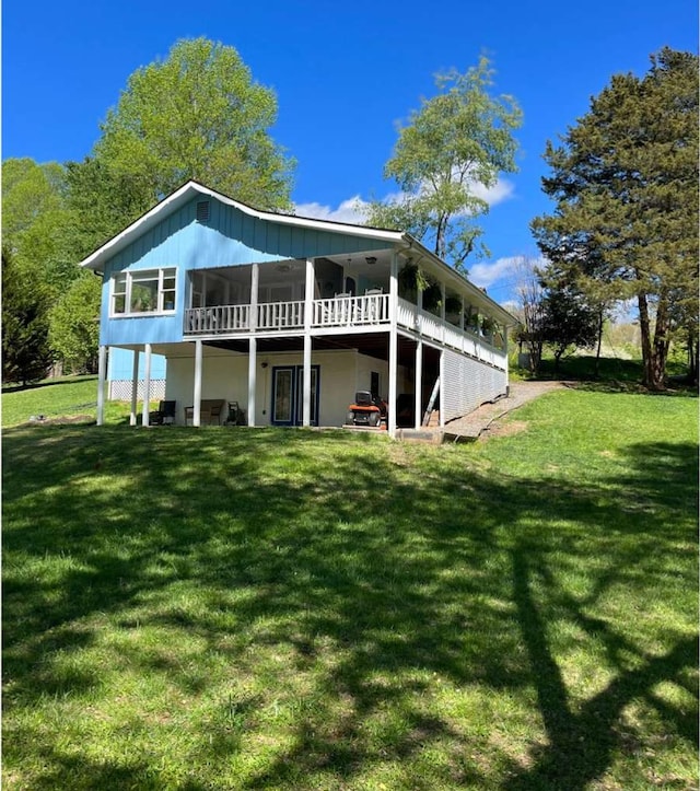 back of house with a sunroom and a yard