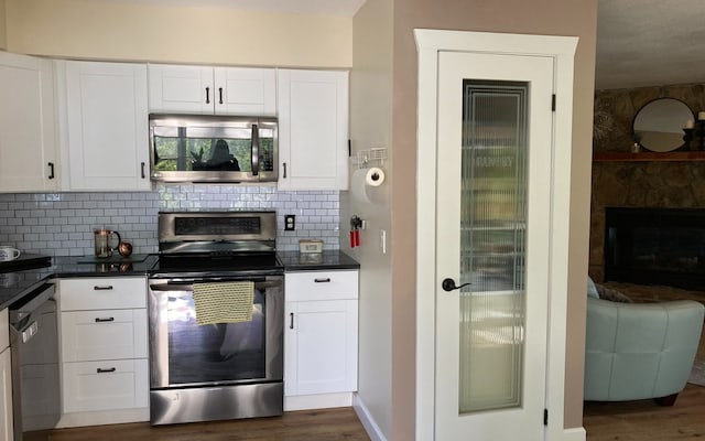 kitchen featuring backsplash, dark hardwood / wood-style flooring, white cabinets, and stainless steel appliances