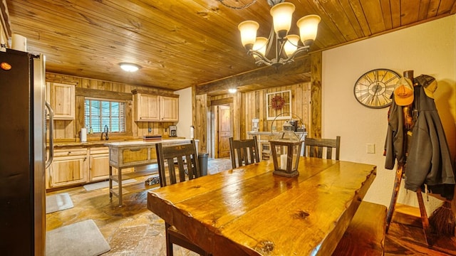 dining space with stone finish floor, a notable chandelier, and wood ceiling