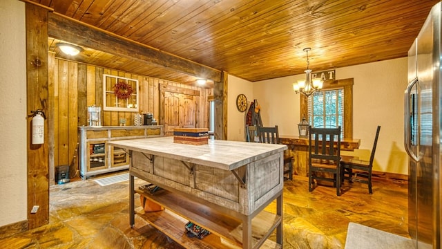 kitchen featuring light countertops, stainless steel fridge, a notable chandelier, hanging light fixtures, and wood ceiling