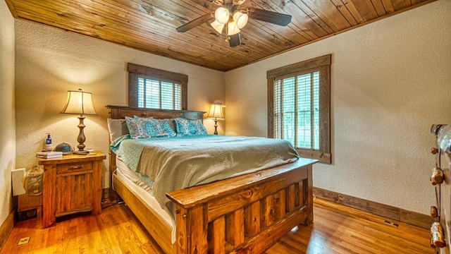 bedroom with wooden ceiling, a ceiling fan, baseboards, light wood-style floors, and a textured wall