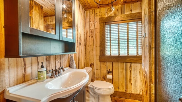 bathroom with wooden ceiling, wood walls, toilet, and vanity