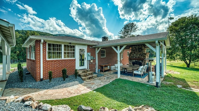 view of front of house with brick siding, a front yard, a patio, and entry steps