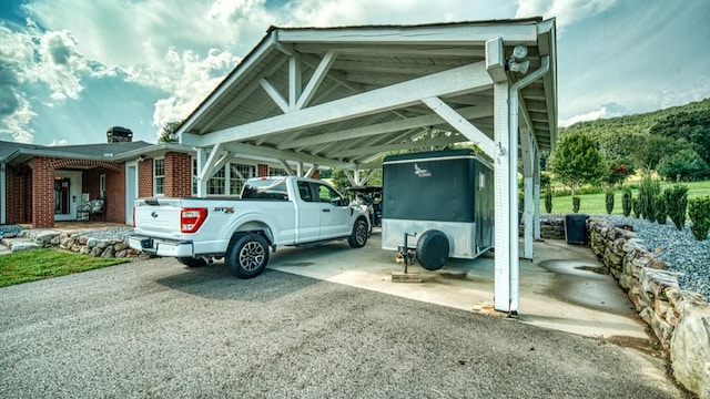 view of vehicle parking with driveway and a carport