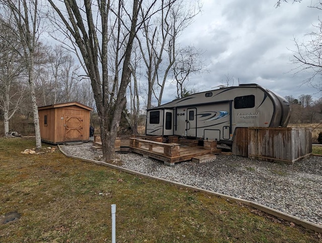 view of yard featuring a storage shed and a wooden deck