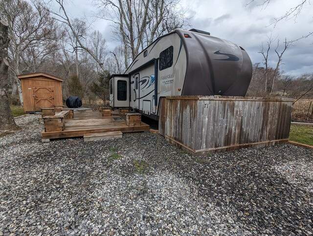 view of yard featuring a deck and a storage unit