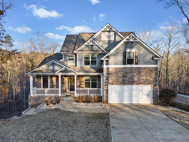 craftsman house featuring stone siding, covered porch, concrete driveway, and an attached garage