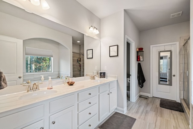9475 Dunmoore Dr, Cumming, GA 30028 - bathroom featuring a shower stall, double vanity, visible vents, and a sink